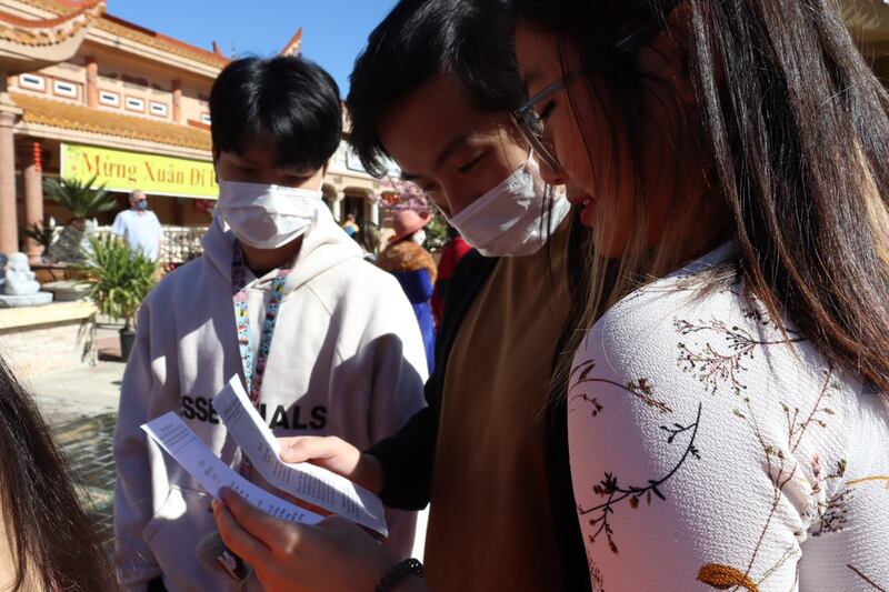 Bao Quang Temple visitors pick up the card that matches the number on the bamboo stick they shuffled.