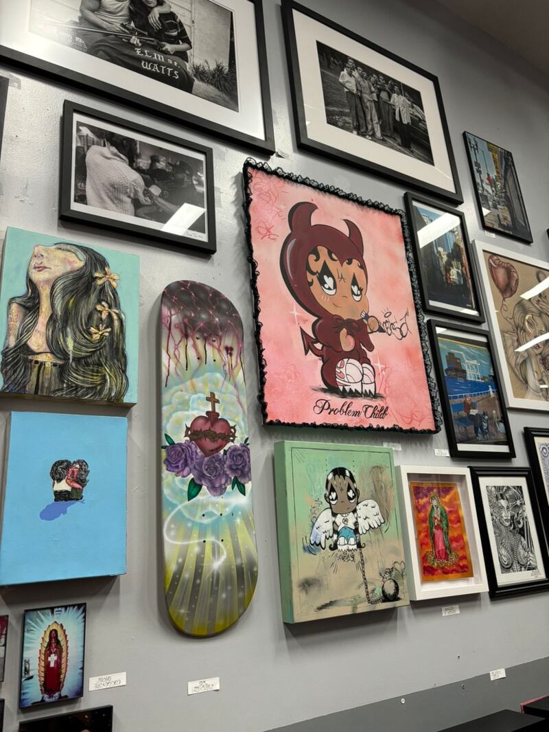 Photo of colorful paintings on a white wall.