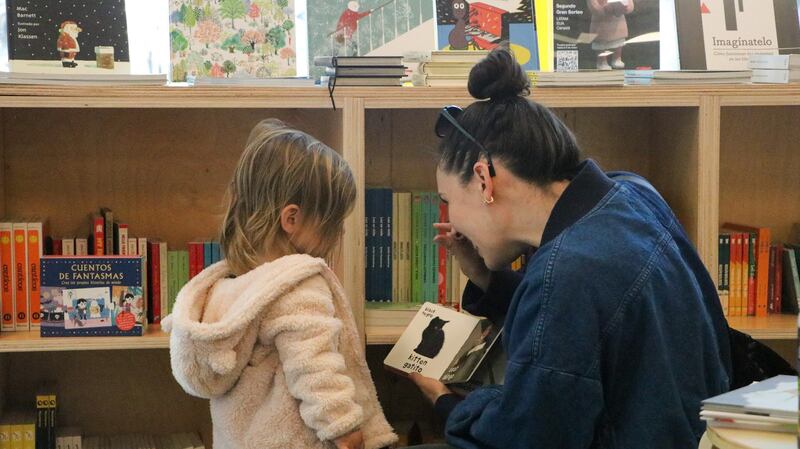Photo of a mother and her child looking at a book at a bookstore.