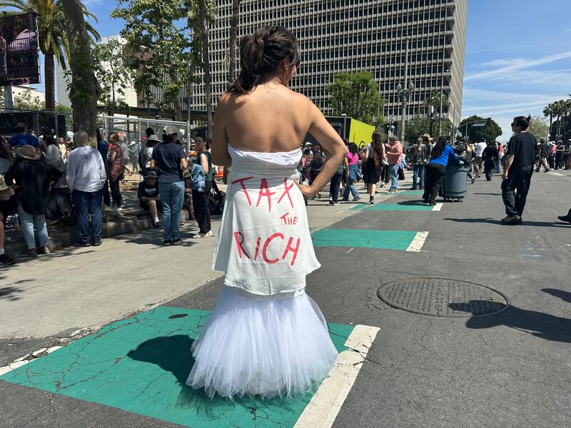 Photo of a woman recreating New York Rep. Alexandria Ocasio-Cortez’s 2021 MET Gala “Tax the Rich” dress.