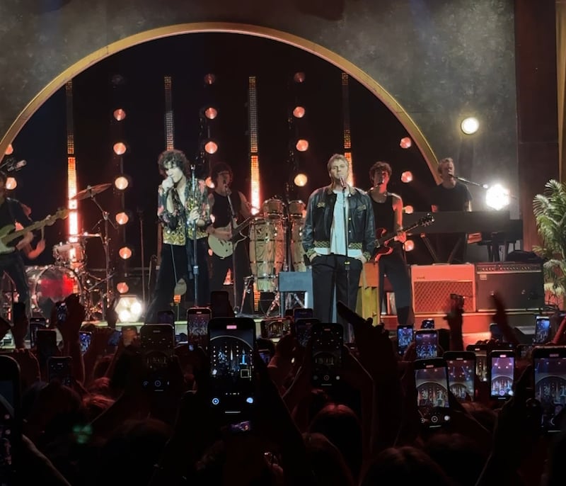 Two singers sing together onstage.