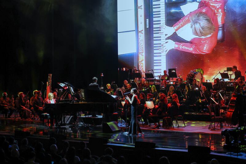 Photo of a stage with an orchestra, pianist and singer