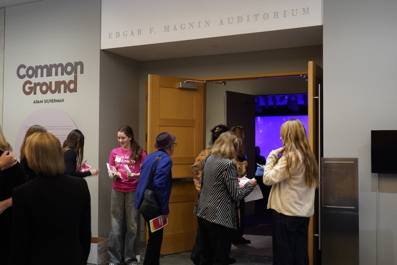 年轻志愿者在活动现场接待来宾。