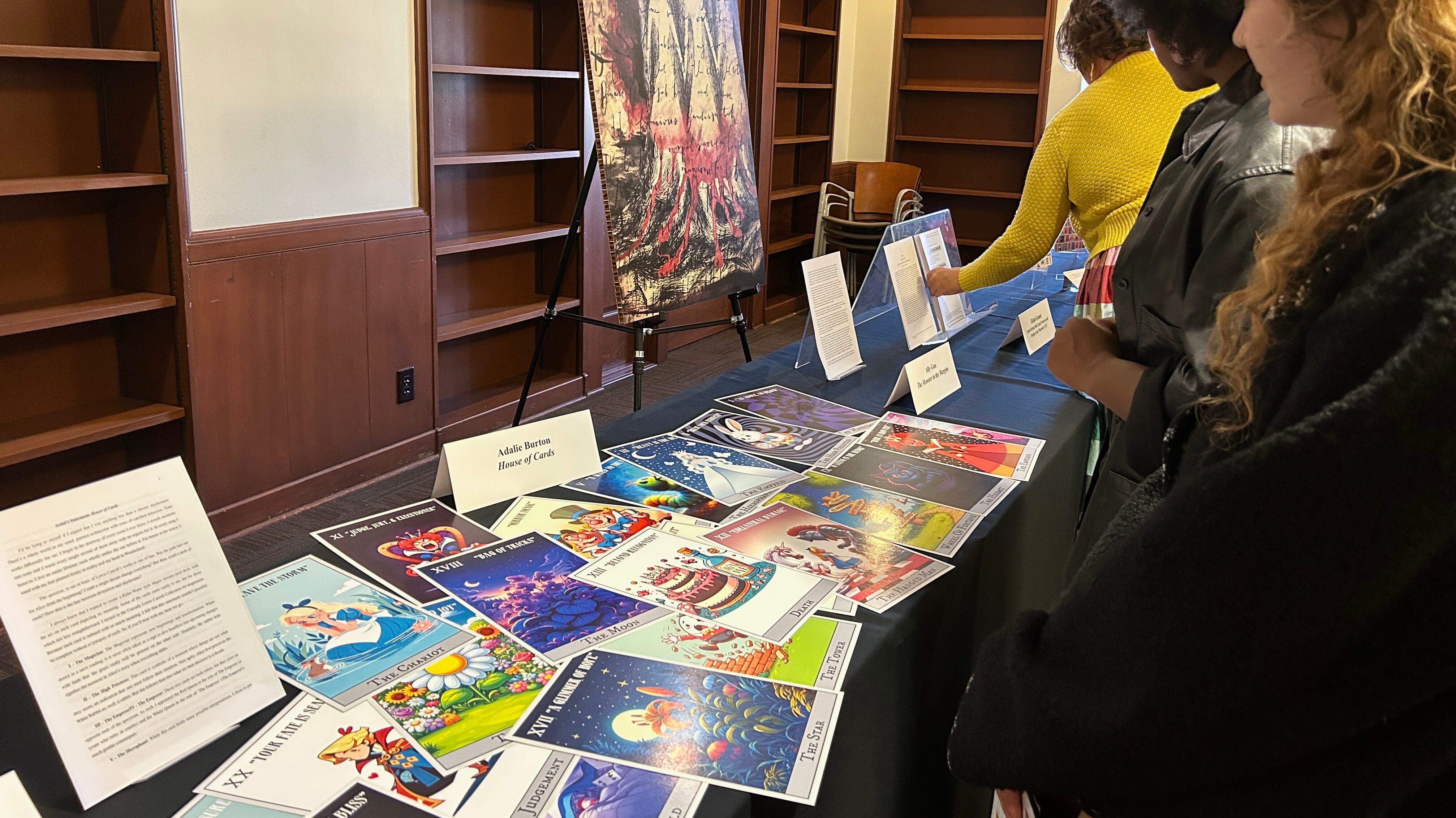Students look at items on display, including a large tarot deck, a painting and writing.