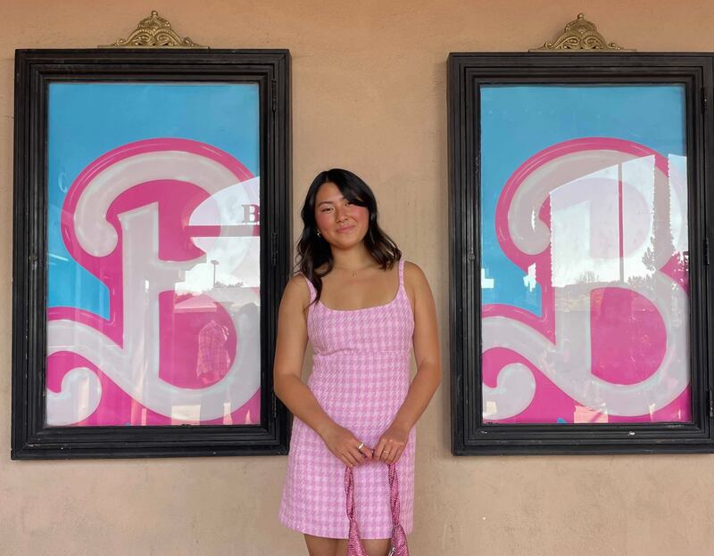 Photo of a woman posing in front of two posters with the letter "B" on it
