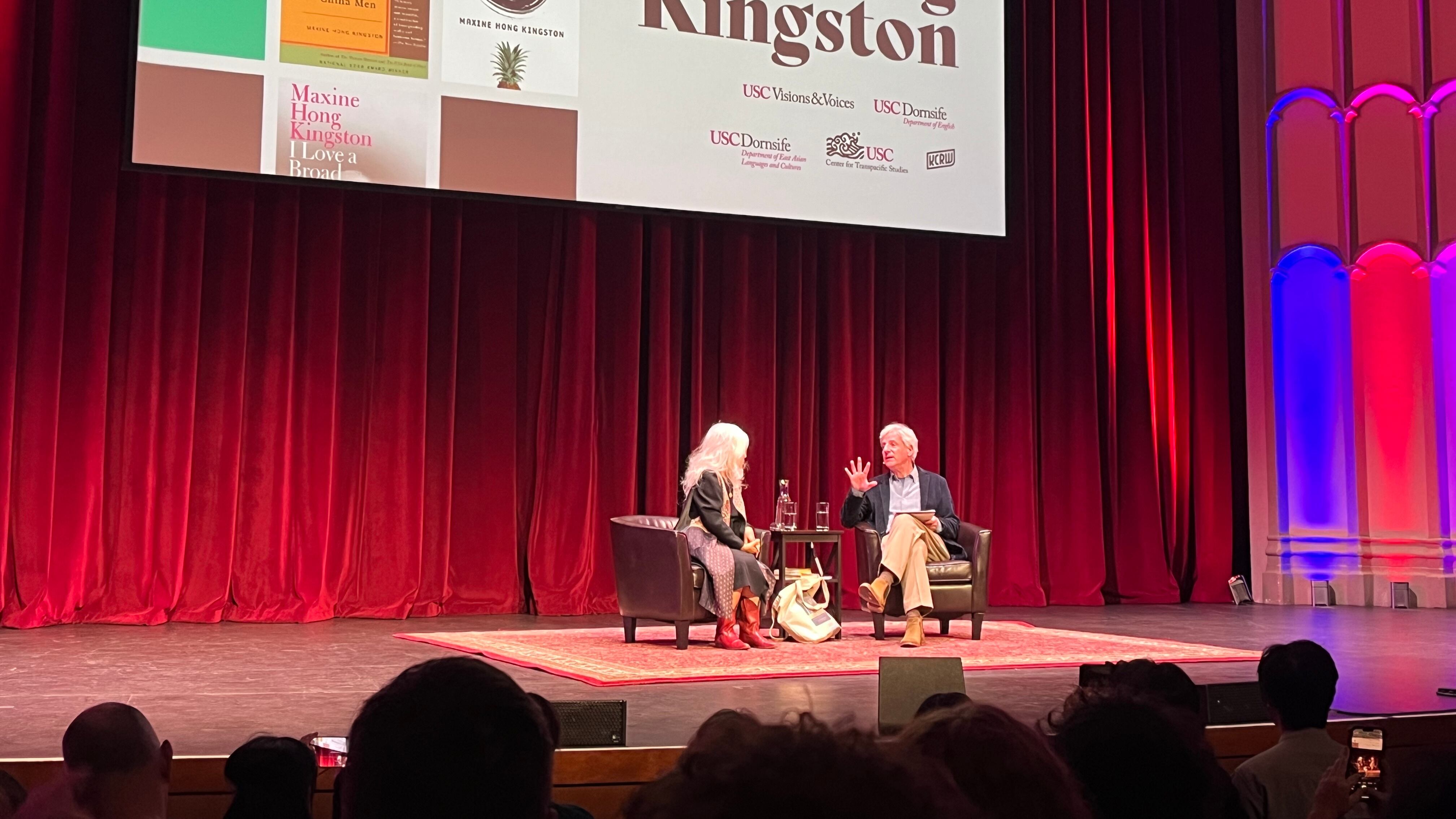 Photo of two people sitting on a stage