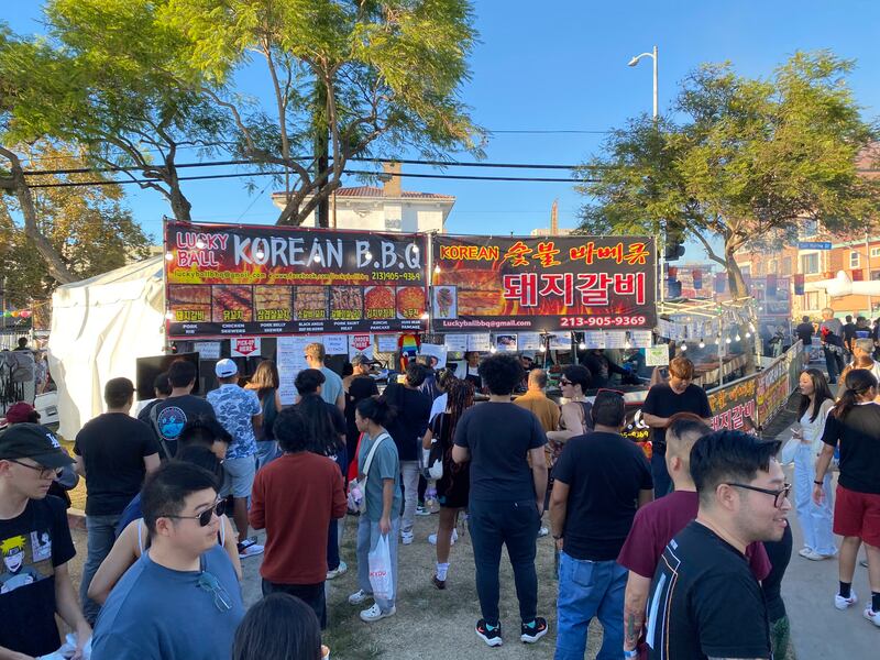 Photo of a crowd of people lining up in front of a stand