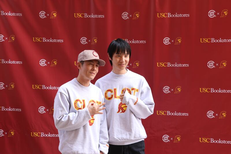 Photo of two people posing in front of a red background