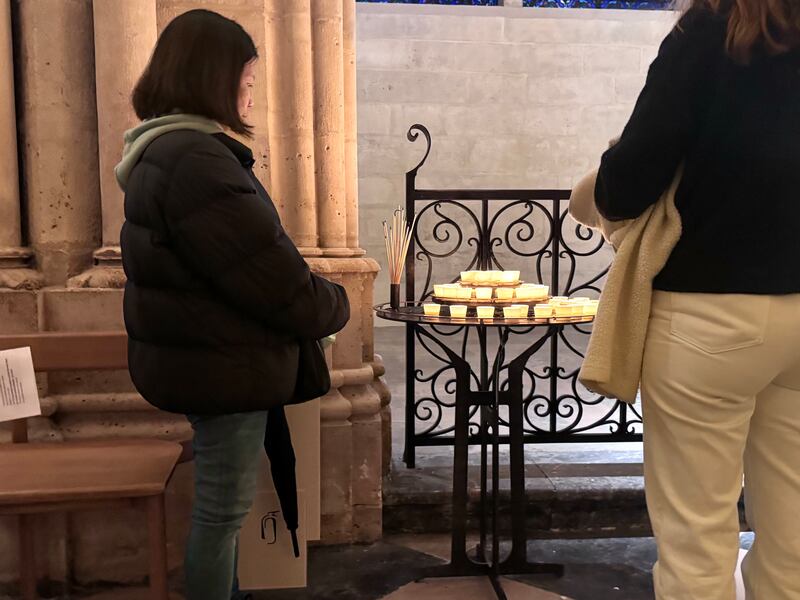 Visitors to Notre-Dame Cathedral light candles during an evening vigil honoring Pope Francis’ passing. (Photo by Charlotte Calmès)