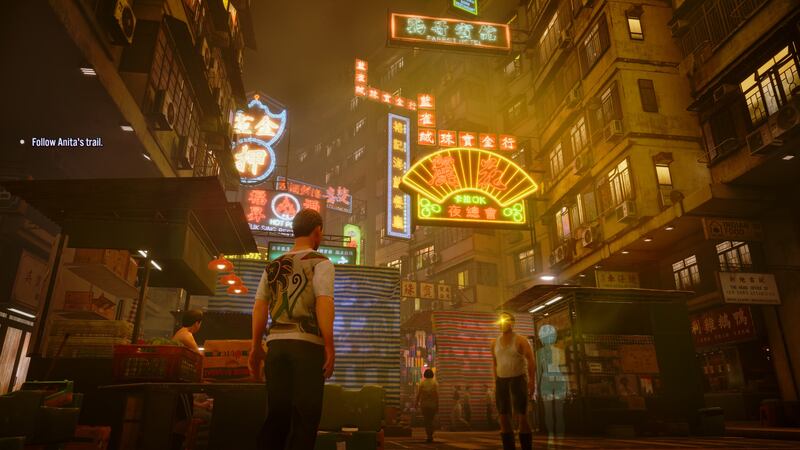 Game screenshot of a man standing in front of numerous towering buildings and neon signs