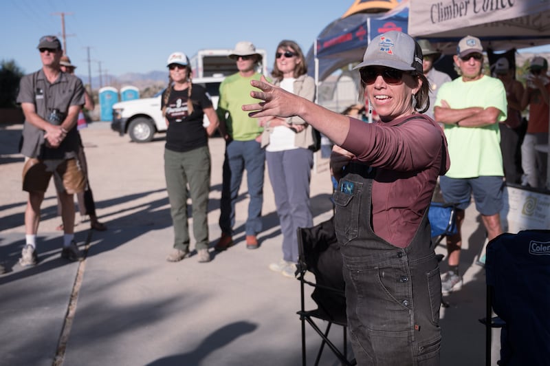 Sabra Purdy, the owner of Cliffhanger Guides, a climbing guide service at Joshua Tree National Park, directs volunteers to their respective teams. 80 volunteers were spread across Hidden Valley, Yucca Valley and 29 Palms to clean up trash and graffiti. (Photo by Michael Chow)