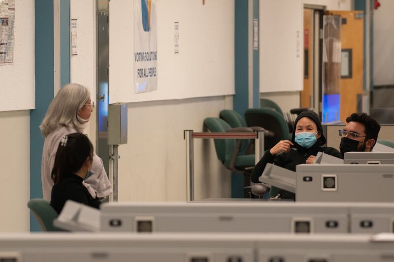 Workers chat while waiting to count ballots at the Tally Operations Center. (Photo by Jason Goode)