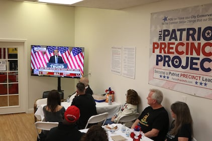 Attendees at Trump HQ watching Trump's speech on Fox News.