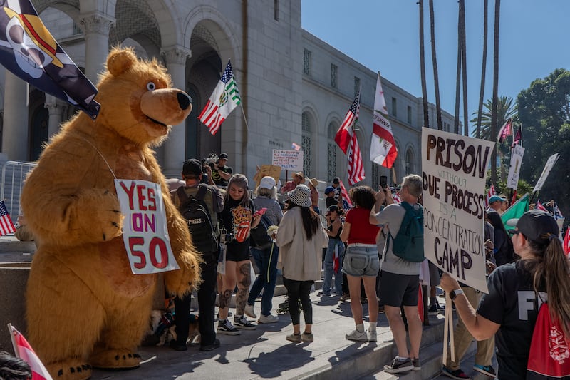 Demonstrators stand on the steps of the Los Angeles City Hall.