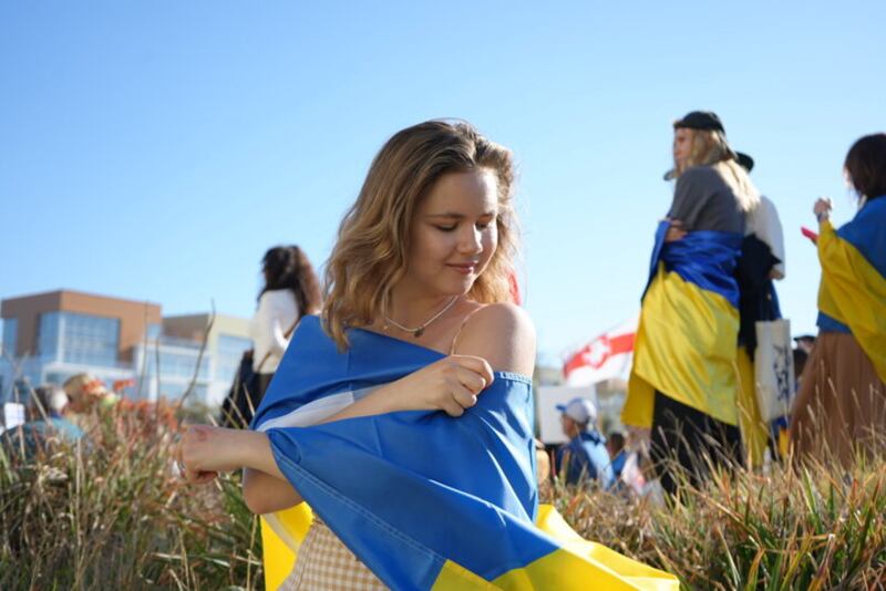 Photo of a Ukrainian USC student wrapping herself in a flag to show support.