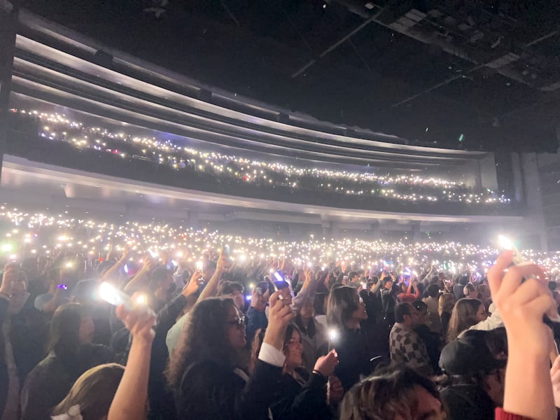 Photo of a crowd of people holding white lights