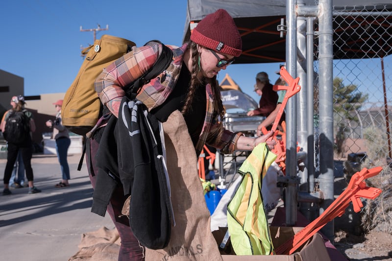 Rina, a volunteer from the Pure Project, picks up burlap sacks, safety vests and tools for picking up the trash. (Photo by Michael Chow)