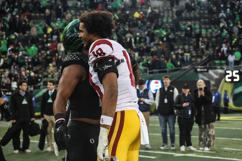 USC's Eric Gentry (18) shares a postgame embrace with an unidentified Oregon player.