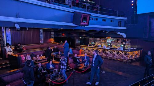 Press and staff around the press section of Schiff's watch party which is behind the high rise.