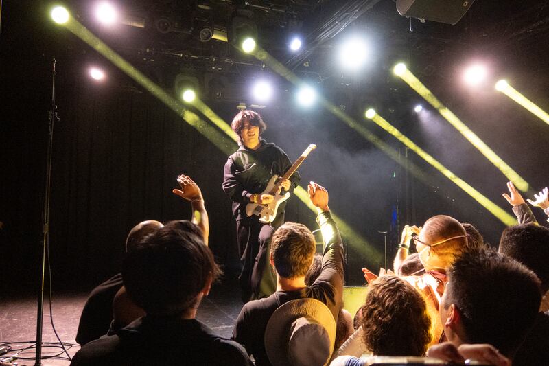 Guitarist looks towards the audience.