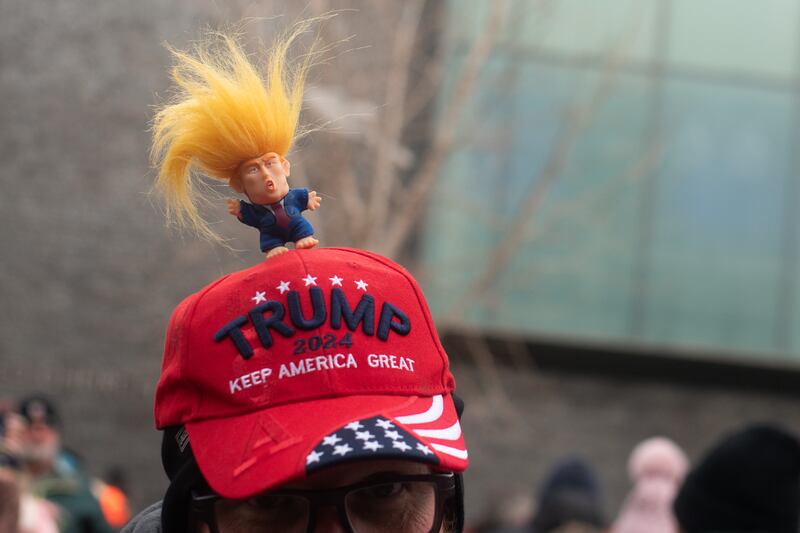 A picture of a Trump hat with a Trump doll on top.