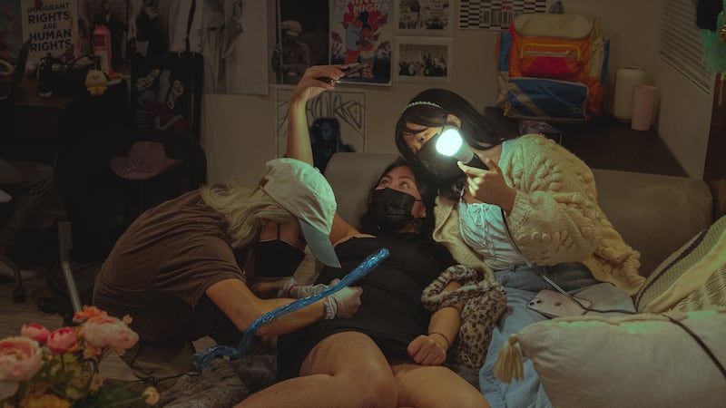 Võ takes a selfie to document Zhang tattooing her. Set inside of their college apartment, Zhang’s tattoo sessions are both intimate and memorable. (Photo by Alex Lam)