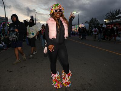 A photo of a fan wearing an outfit with homemade accessories, including boots and a hat with mini teddy bears on them.