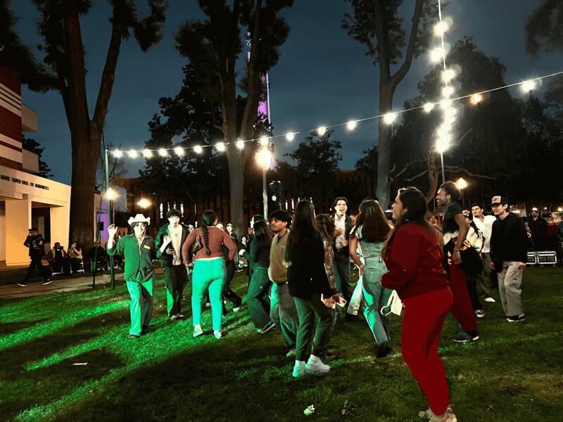 Photo of people dancing on grass.