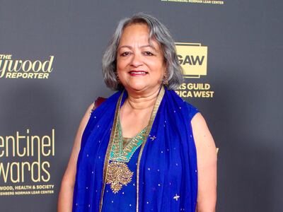 A photo of Chakravarty smiling and posing in a blue dress on the red carpet.