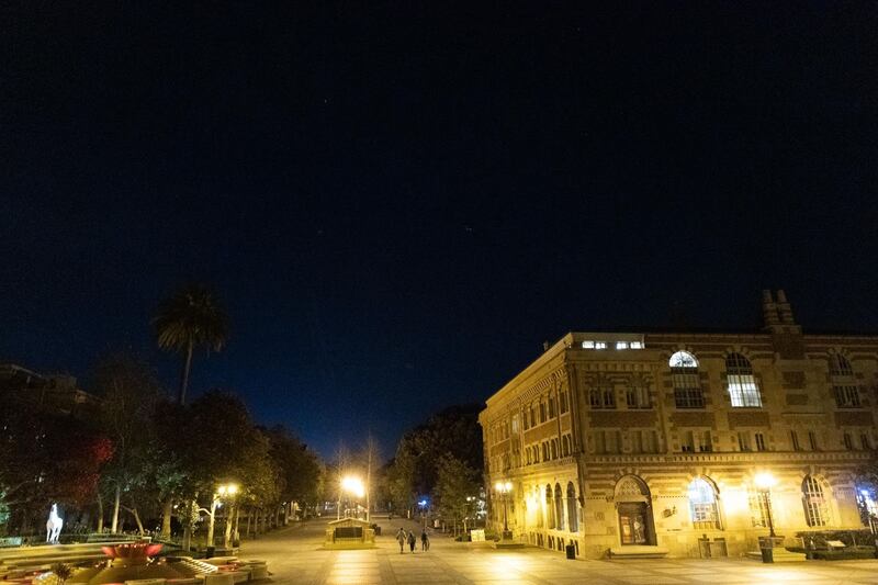 A photo of campus at night as Nivea Krishnan, Benjy Mitchell, and Jack Goldman walk across.