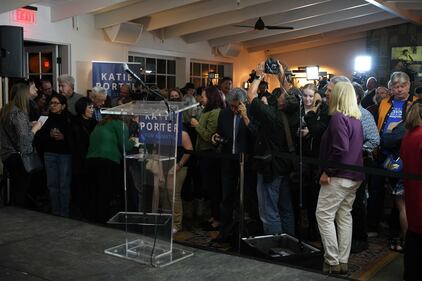 The audience waits for Katie Porter to speak a few feet away from the stage.