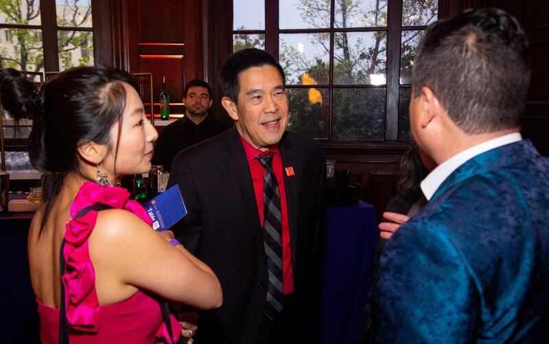 Photo of three people speaking to each other