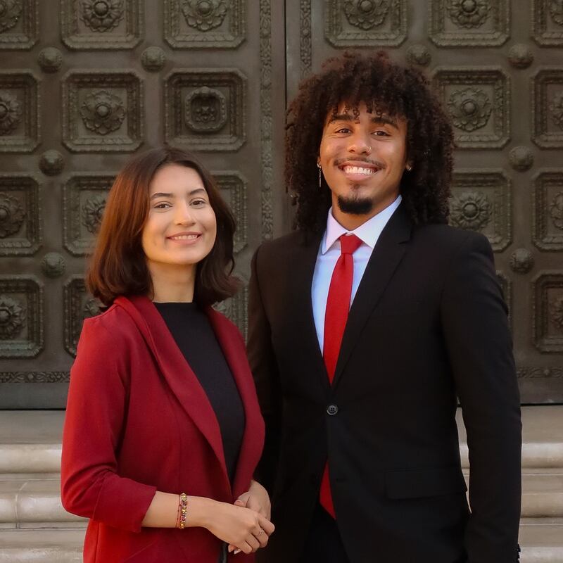 Photo of two people posing and smiling.