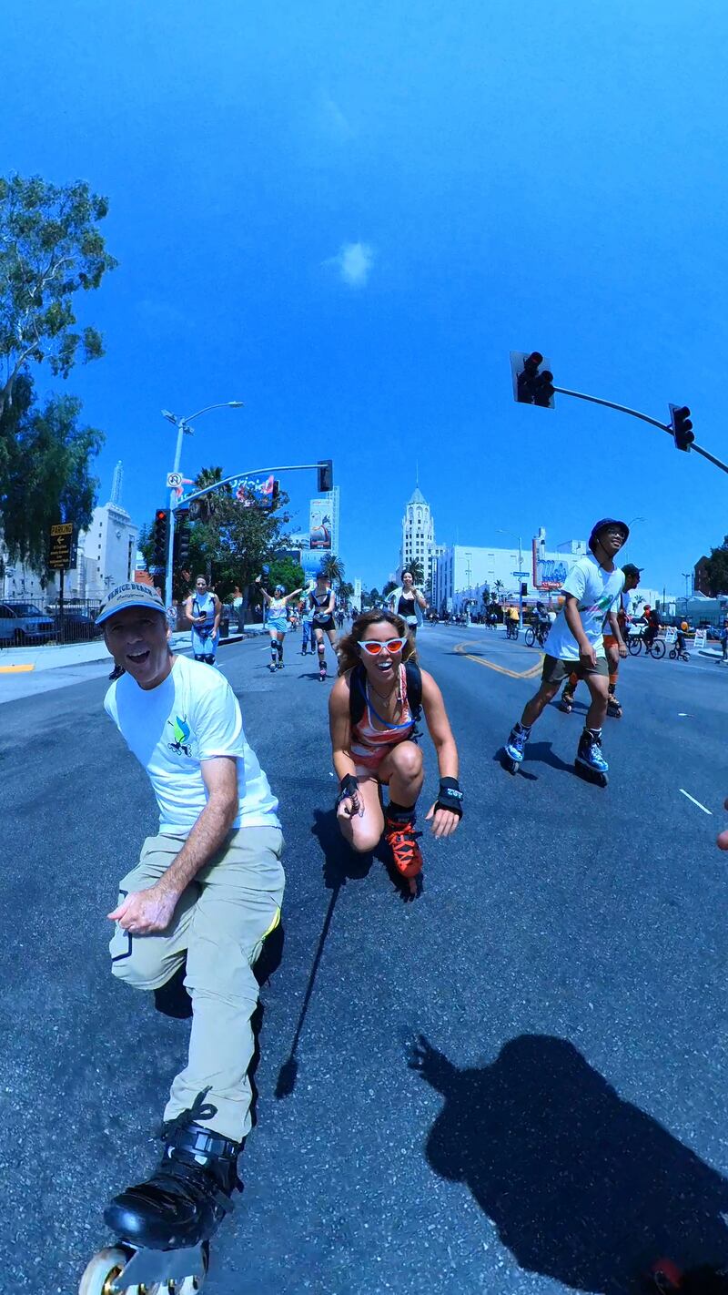 Group of people on roller skates in the street.