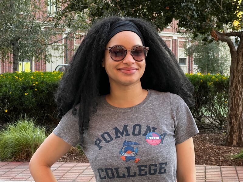 Russ standing in front of greenery, wearing an "I Voted" sticker.