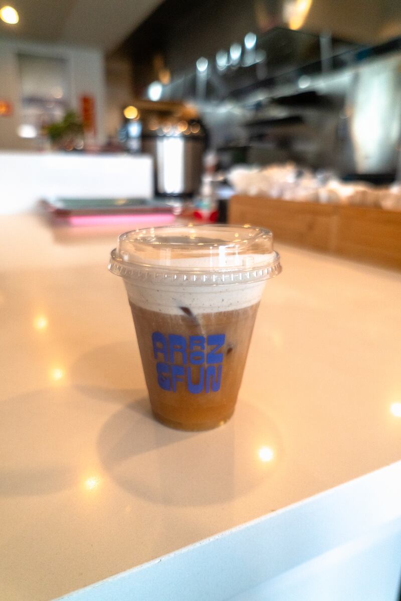 Photo of a coffee cup with blue lettering on it.