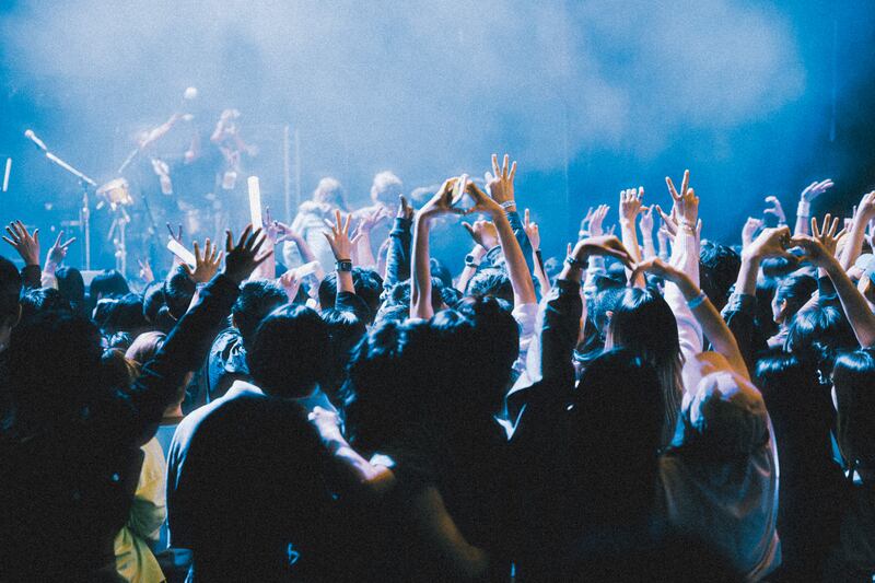 Photo of a crowd of people raising their hands
