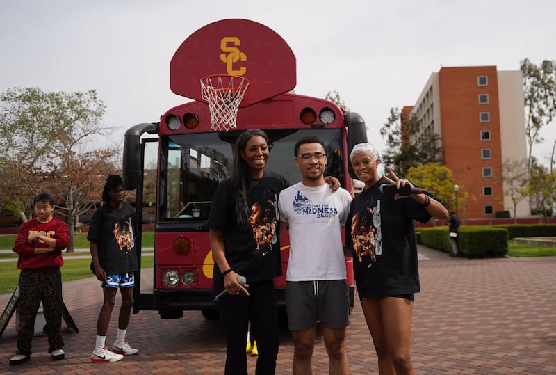 USC Spring transfer Sammie Arnold wins tickets to the USC vs. UCLA game, standing in front of a red USC-branded bus.