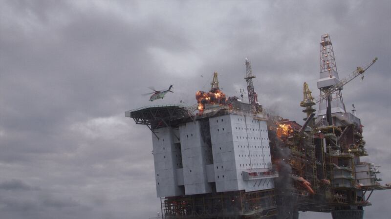 A shot from "The Burning Sea" where a helicopter hovers over a burning ship with rigs.