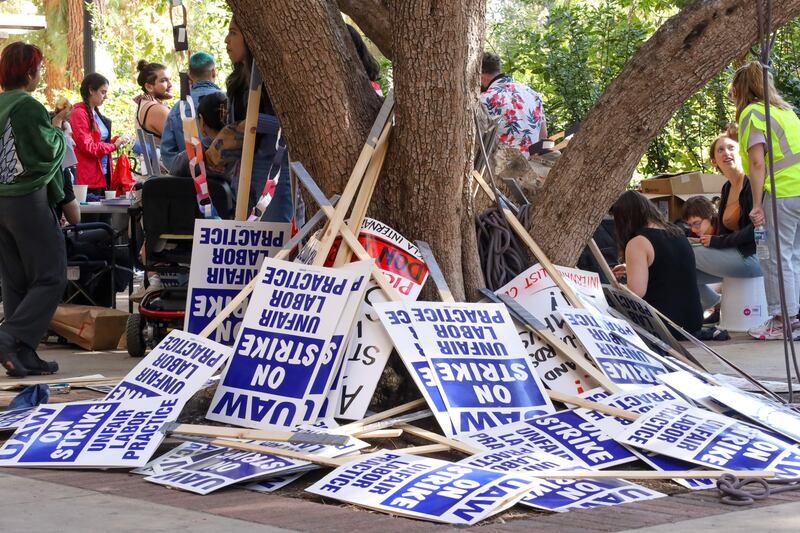 Spare protest signs stating "UAW, ON STRIKE, UNFAIR LABOR PRACTICES."
