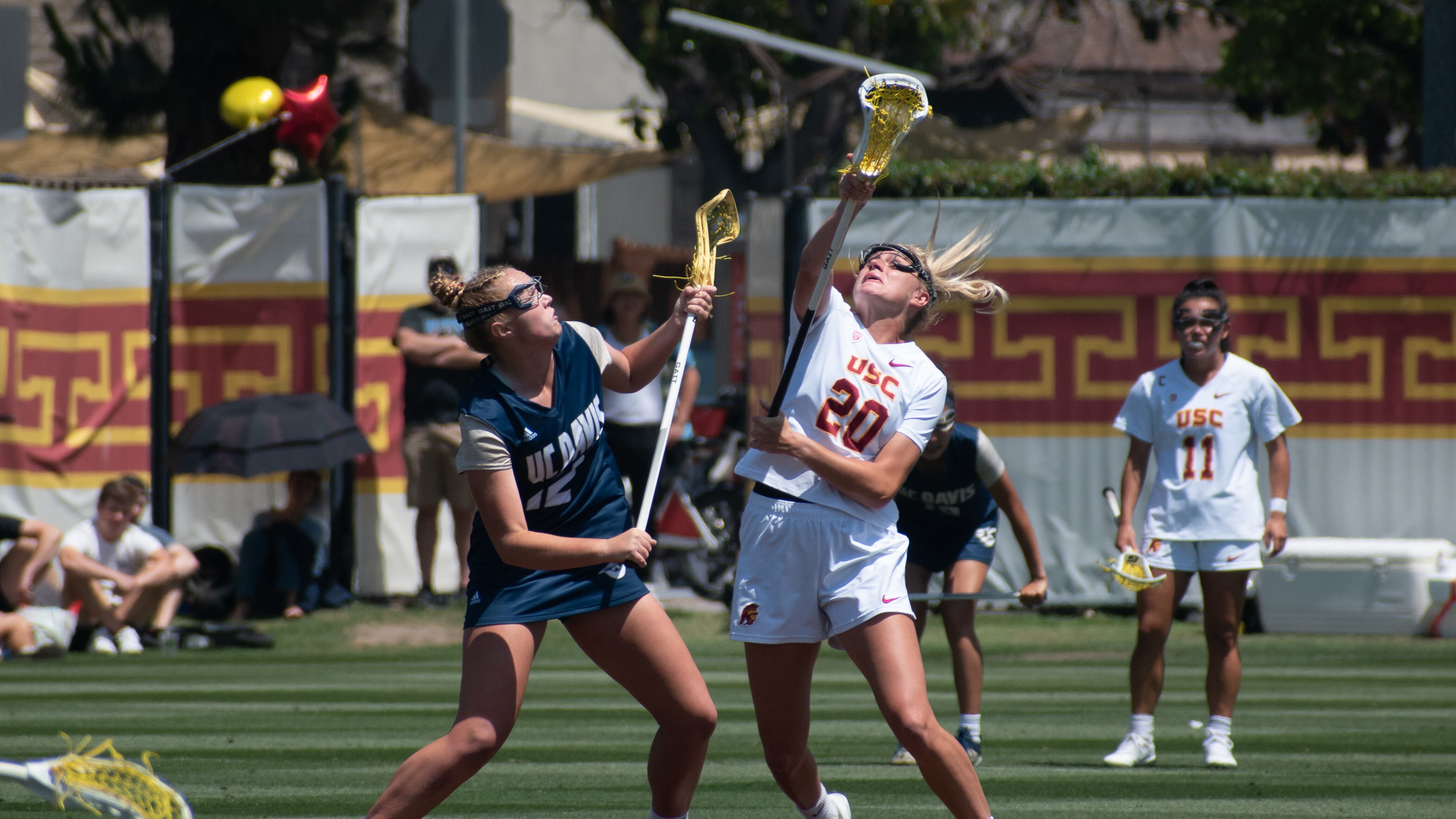 Graduate student midfielder Katie Ramsay reaches up for the ball with her stick.