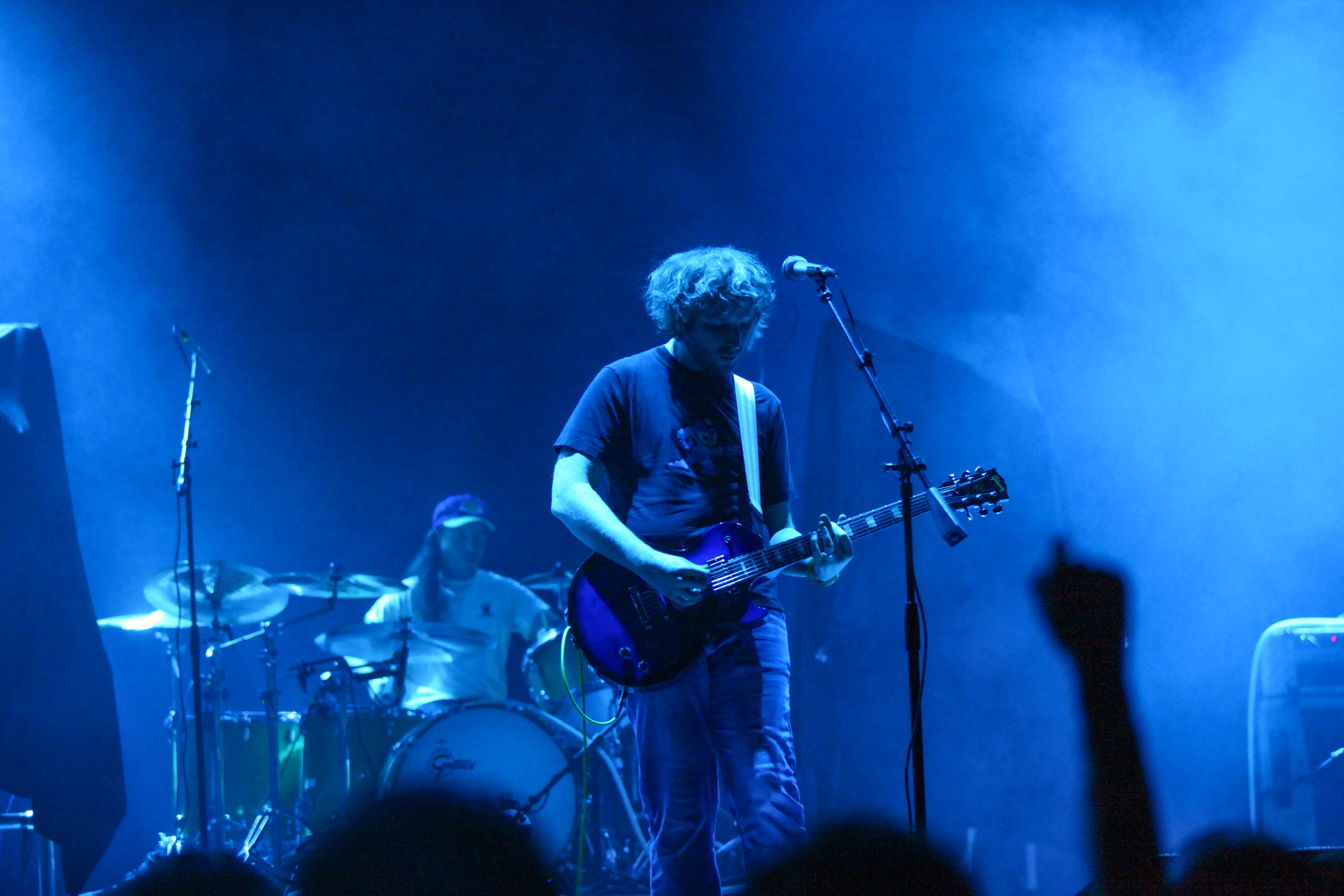 Guy playing guitar with blue lights above