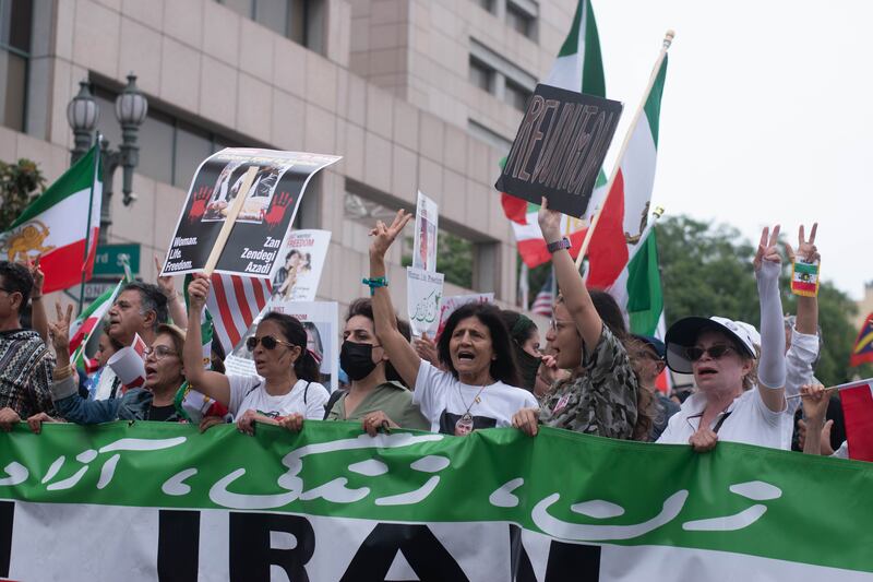 Protesters of Iran’s government hold signs calling for revolution and freedom in Iran while chanting Zan. Zendegi. Azadi. Which translates to Woman, Life, Freedom.