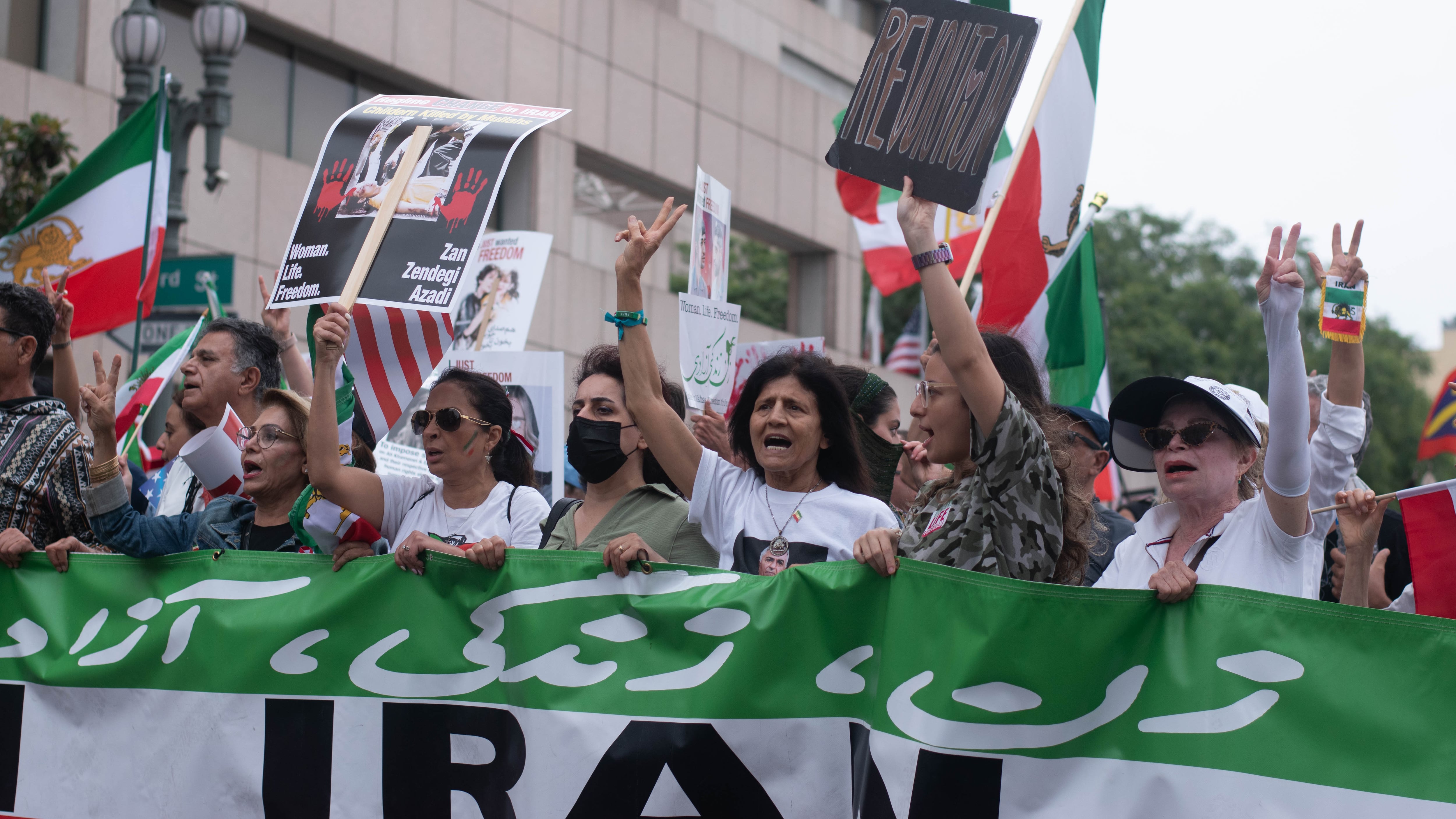 Protesters of Iran’s government hold signs calling for revolution and freedom in Iran while chanting Zan. Zendegi. Azadi. Which translates to Woman, Life, Freedom.