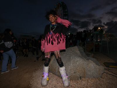 A photo of a fan posing in a black oversized sweatshirt with pink flames on it.