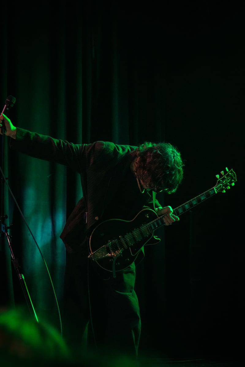 Holiday surrounded by green light with guitar.