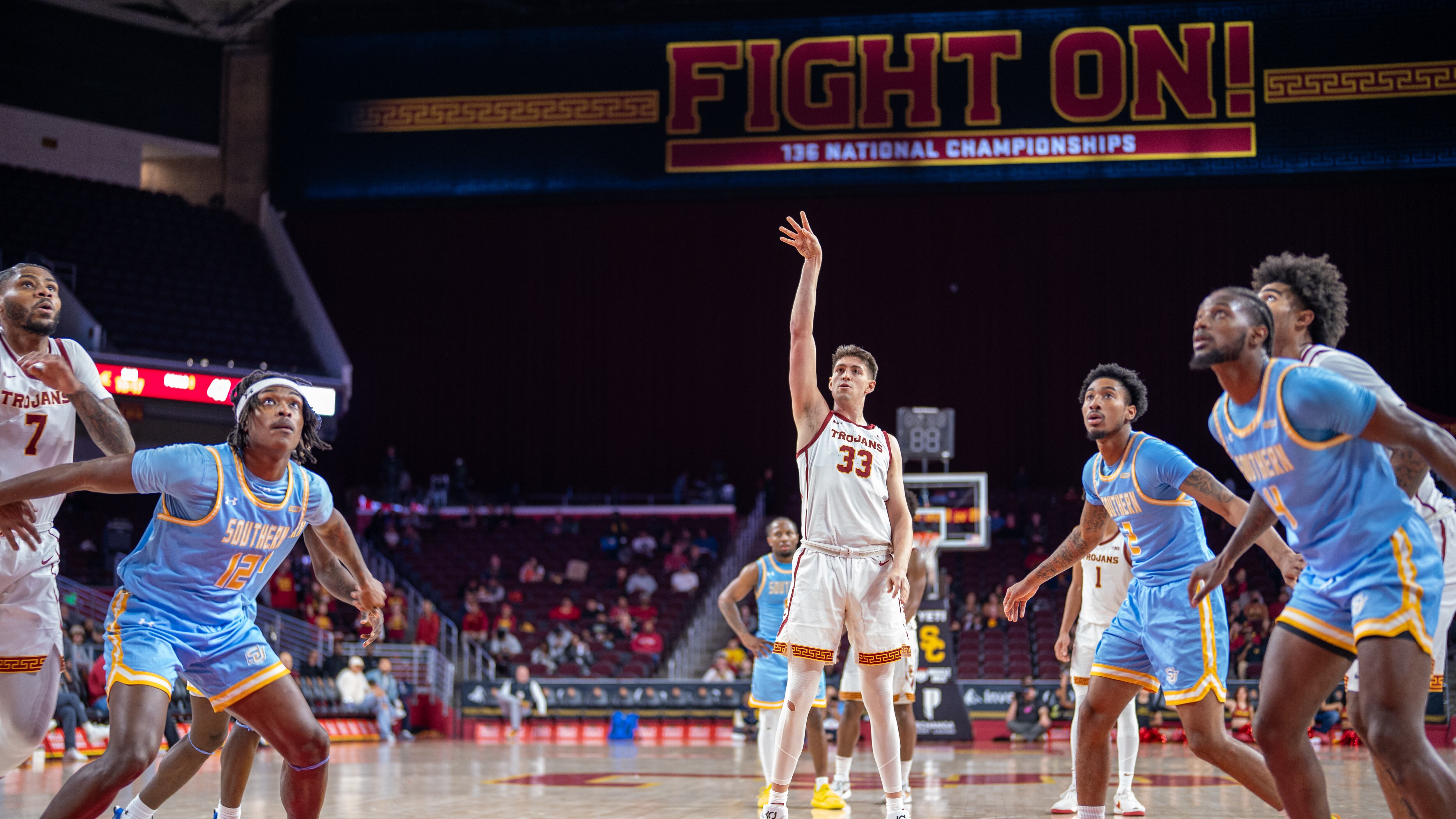 A photo of Josh Cohen, wearing a white USC jersey, shooting a free throw.