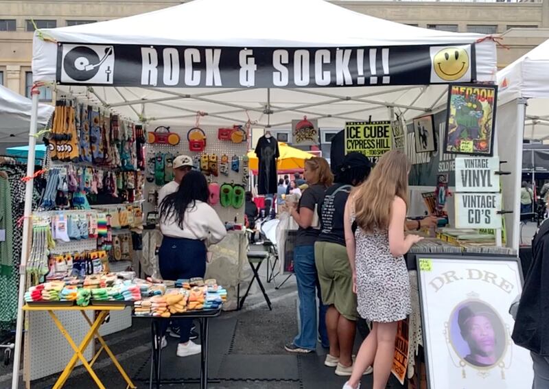 A photo of a tent with merchandise and a sign that says "Rock and Sock!!!"