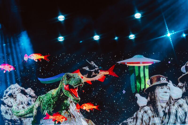 Photo of a stage featuring a stage decorated with fish, a dinosaur, a UFO, and rocks