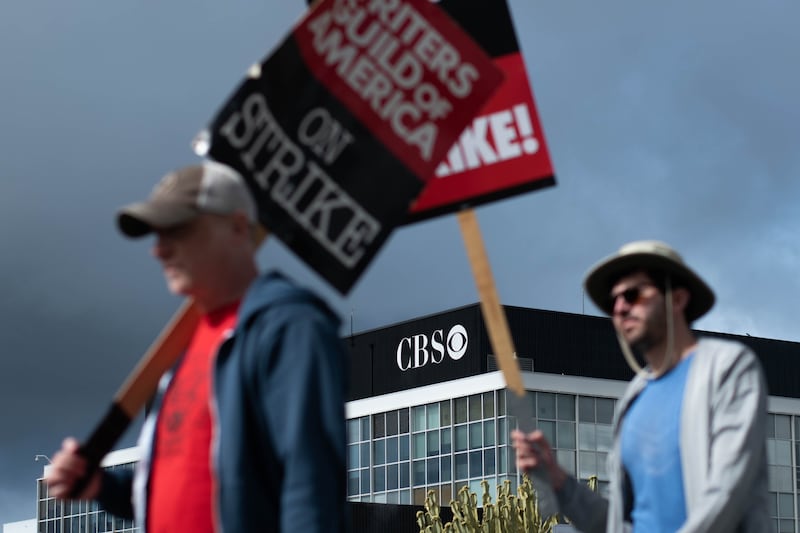 Protesters at the WGA strike walk in front of the CBS TV City building .